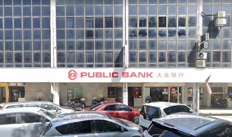 Pemandangan hadapan cawangan Public Bank Taman Melawati dengan papan tanda premis dan deretan kereta yang diletakkan di bahagian hadapan.