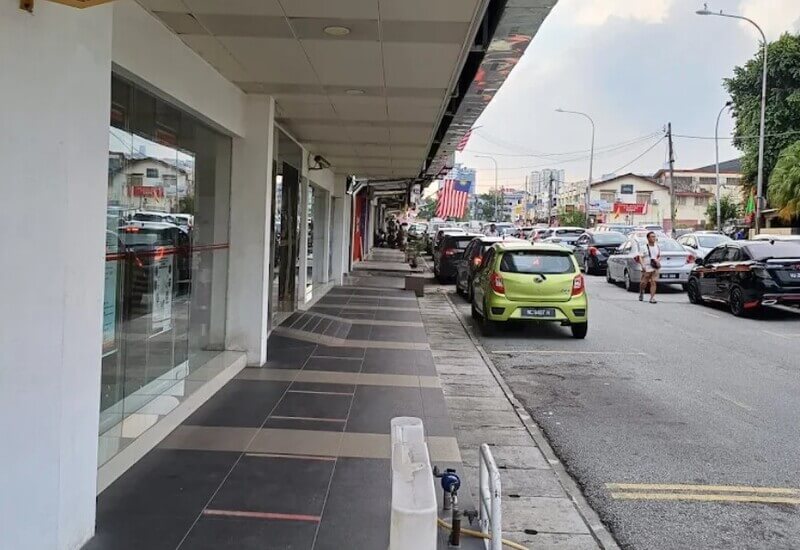 Pandangan kaki lima premis kedai berhampiran cawangan Public Bank di Taman Midah dengan deretan kereta diletakkan di tepi jalan.