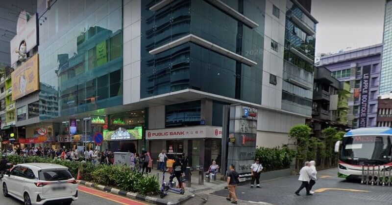 Pemandangan luar cawangan Public Bank Bintang Walk di kawasan bandar yang sibuk dengan laluan pejalan kaki, kenderaan, dan bangunan komersial di sekelilingnya.