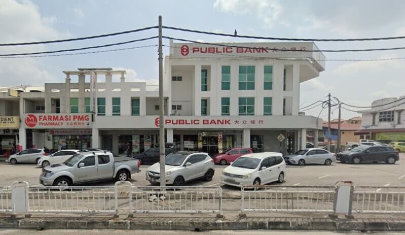 Pandangan luar cawangan Public Bank Seri Manjung dan Farmasi PMG di kawasan rumah kedai dengan pelbagai kenderaan diletakkan di tempat letak kereta.