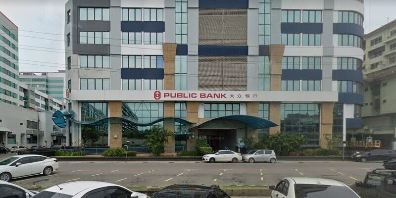Bangunan Public Bank Kota Kinabalu dengan seni bina moden dan papan tanda “Public Bank 大众银行”, menampilkan pejabat bertingkat, tingkap kaca, pintu masuk utama dan beberapa kenderaan di hadapan bangunan.