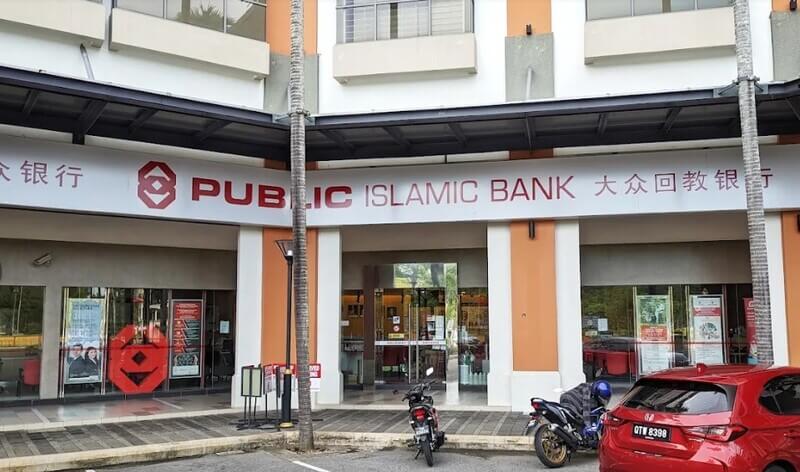 Pintu masuk cawangan Public Bank Miri dengan papan tanda merah dan putih, serta beberapa kenderaan diletakkan di bahagian hadapan.