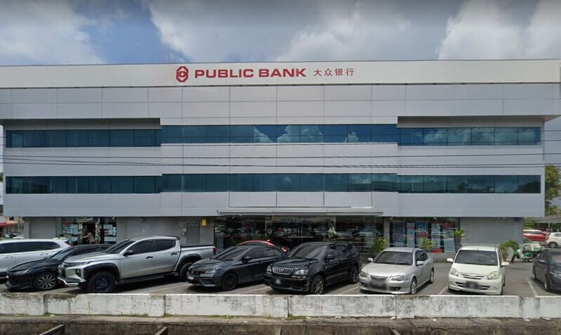 Bangunan cawangan Public Bank Pelita tiga tingkat dengan papan tanda nama bank dan beberapa kenderaan diletakkan di tempat letak kereta di hadapannya.
