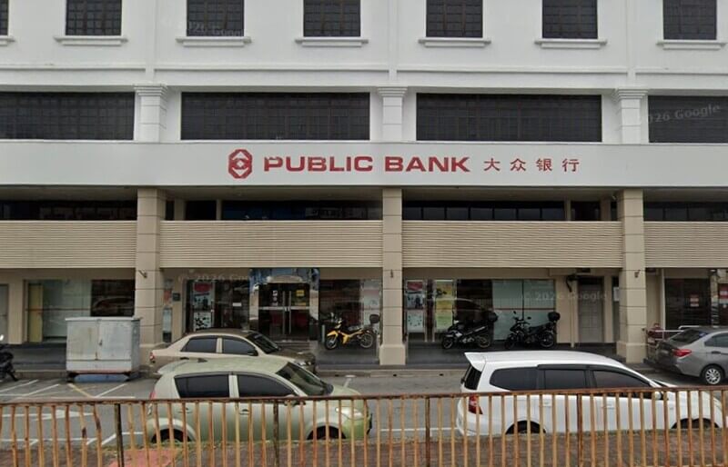 Pandangan hadapan cawangan Public Bank Rasah dengan papan tanda bercetak nama bank dalam bahasa Inggeris dan Cina, serta kenderaan yang diletakkan di hadapan bangunan.
