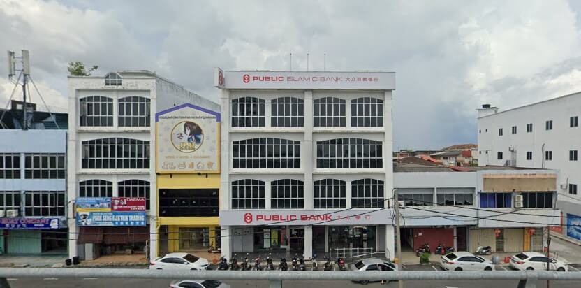 Bangunan cawangan Public Bank Sekinchan dan Public Islamic Bank empat tingkat berwarna putih di Sekinchan dengan beberapa buah kereta dan motosikal di hadapannya.