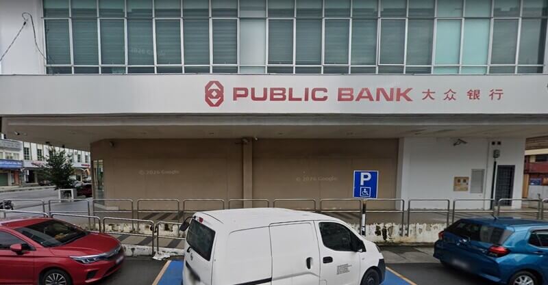 Pandangan hadapan cawangan Public Bank Seremban dengan papan tanda logo dan tulisan cina, serta beberapa buah kenderaan diletakkan di bahagian hadapan.