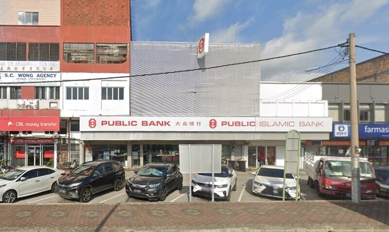 Pandangan hadapan cawangan Public Bank dan Public Islamic Bank di Sitiawan dengan beberapa buah kenderaan diletakkan di petak letak kereta di bahagian hadapan.