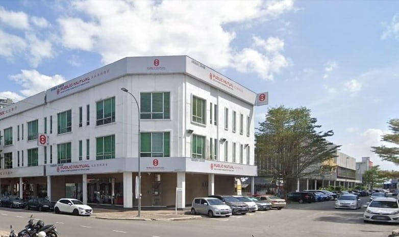Bangunan komersial sudut tiga tingkat dengan fasad putih dan tingkap menegak hijau. Bangunan ini mempunyai papan tanda "PUBLIC MUTUAL" berwarna merah dan putih pada semua sisi dan lantai yang boleh dilihat, kadangkala disertai dengan aksara Cina. Terdapat juga logo merah yang tersendiri (menyerupai huruf 'P' yang digayakan) berhampiran bahagian atas bangunan di kedua-dua sisi yang menghadap jalan