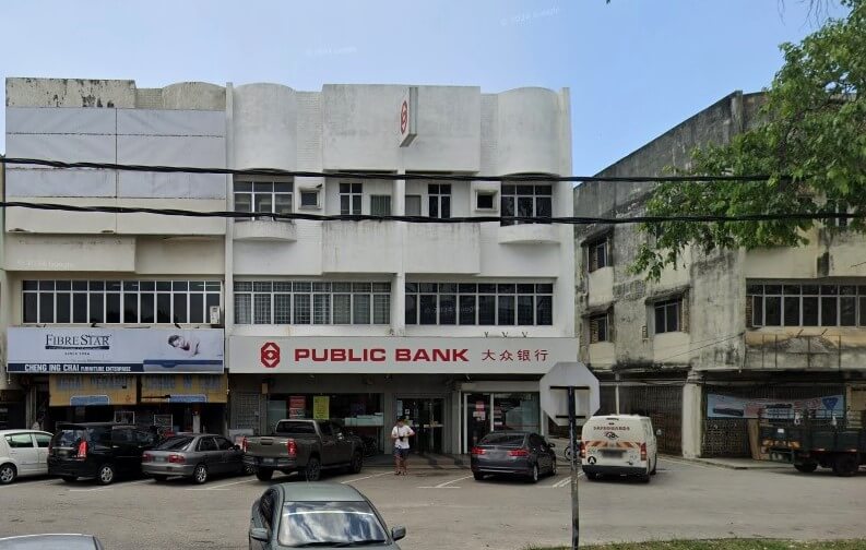 Bahagian luar cawangan Public Bank di Ayer Tawar. Bangunan ini ialah bangunan komersial putih tiga tingkat dalam gaya art deco atau pertengahan abad yang tersendiri, dengan tepi melengkung di bahagian atas fasad