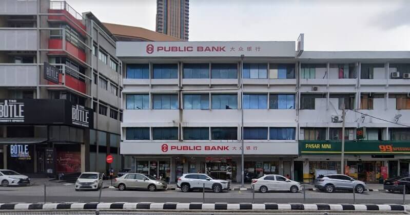 Pemandangan luar cawangan Public Bank Changkat Thambi Dollah di kawasan kedai tiga tingkat, dengan papan tanda "PUBLIC BANK 大众银行" di bahagian atas dan tingkat bawah, dikelilingi oleh premis perniagaan lain seperti "THE BOTLE" dan "99 SPEEDMART".