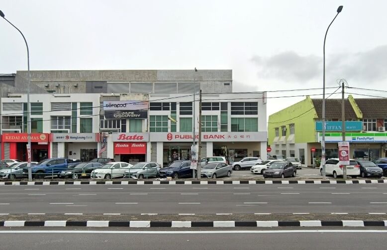 Gambar jalan yang menunjukkan deretan rumah kedai dan perniagaan, di Jalan Sultan Nazrin Shah, Gunung Rapat, Malaysia. Perniagaan terkenal termasuk cawangan Public Bank merah dan putih yang besar, kedai kasut Bata, cawangan Hong Leong Bank dan kedai serbaneka FamilyMart. Beberapa buah kereta diletakkan berdekatan di sepanjang kaki lima di hadapan kedai. Bangunan di bahagian paling kanan dicat dengan warna kuning-hijau terang yang tersendiri