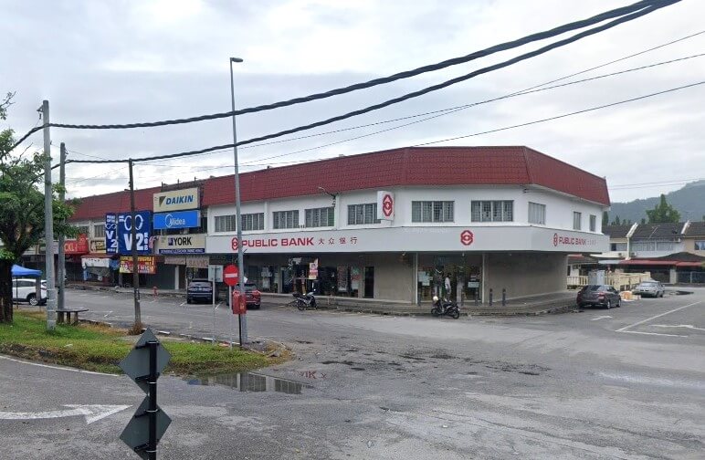 Pemandangan jalan pejabat cawangan Public Bank di Simpang Pulai, sebuah bangunan putih dua tingkat dengan bumbung merah, terletak di sudut jalan