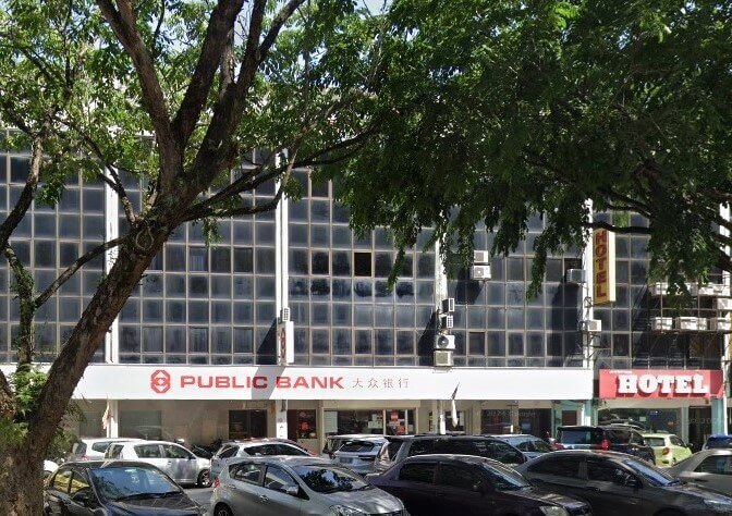Pemandangan jalan Public Bank cawangan Taman Melawati, sebuah bangunan bertingkat dengan fasad tingkap persegi gelap. Tingkat bawah menampilkan muka kedai berwarna putih dengan logo "PUBLIC BANK" dalam aksara merah dan Cina. Papan tanda hotel sebahagiannya kelihatan di sebelah kanan