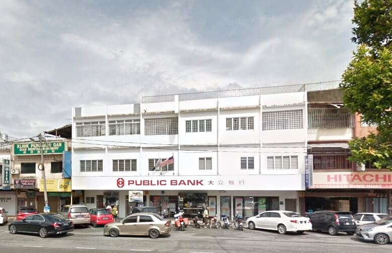 Gambar aras jalan cawangan Public Bank Triang. Bangunan itu adalah struktur putih bertingkat dengan logo bank dan nama yang ditulis dalam huruf merah, termasuk aksara Cina "大众银行," yang dipaparkan dengan jelas di tingkat bawah