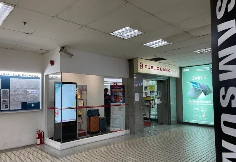 Pintu masuk cawangan Public Bank di dalam bangunan Wisma Saberkas. Di sebelah kiri pintu masuk adalah skrin kaca yang memaparkan skrin digital yang besar, beberapa beg pakaian dan anugerah, bersebelahan dengan Papan Kenyataan dan alat pemadam api