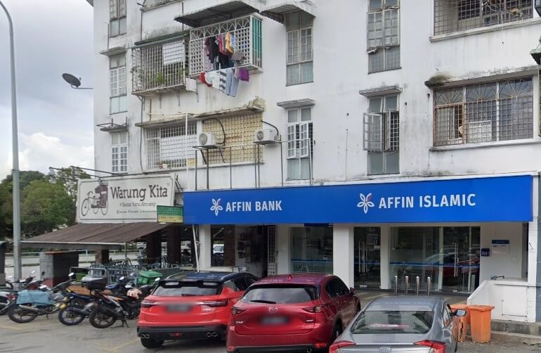 Affin Bank dan cawangan Affin Islamic di tingkat bawah bangunan pangsapuri berwarna putih, dengan papan tanda "Warung Kita" di sebelah kiri, dan beberapa kereta dan motosikal diletakkan di hadapan