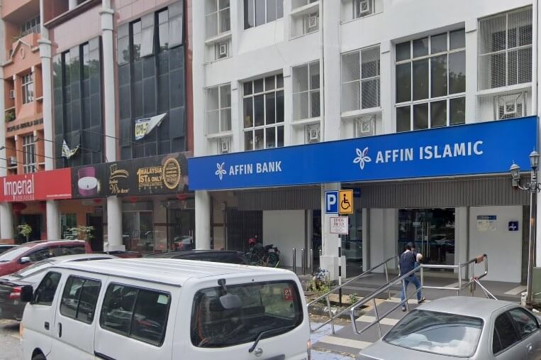 Bahagian luar Affin Bank dan Affin Islamic menampilkan papan tanda biru yang mencolok di atas bangunan putih. Di sebelah kiri, anda boleh melihat tingkap kedai berwarna merah bernama 'Imperial'.