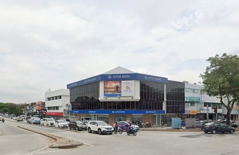 Gambar pemandangan jalan Affin Bank dan Affin Islamic Bank cawangan SS2, sebuah bangunan tiga tingkat dengan tingkap kaca gelap di sudut jalan komersial yang sibuk di Petaling Jaya, Malaysia