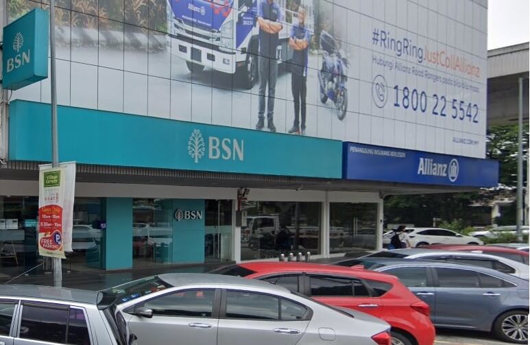 Gambar BSN Desa Jaya Kepong dari aras jalan. Bangunan ini mempunyai tanda BSN biru muda yang besar dengan logo pokok di tingkat atas, dan tanda BSN yang lebih kecil di pintu masuk tingkat bawah. Papan iklan insurans Alliance kelihatan di atas dan di sebelah kanan tanda BSN