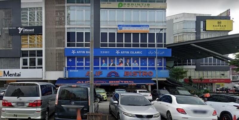 Pemandangan hadapan bangunan komersial yang menempatkan cawangan Affin Bank Balakong, Affin Islamic, dan Restoran Alif Bistro dengan kawasan tempat letak kereta di bahagian hadapan.