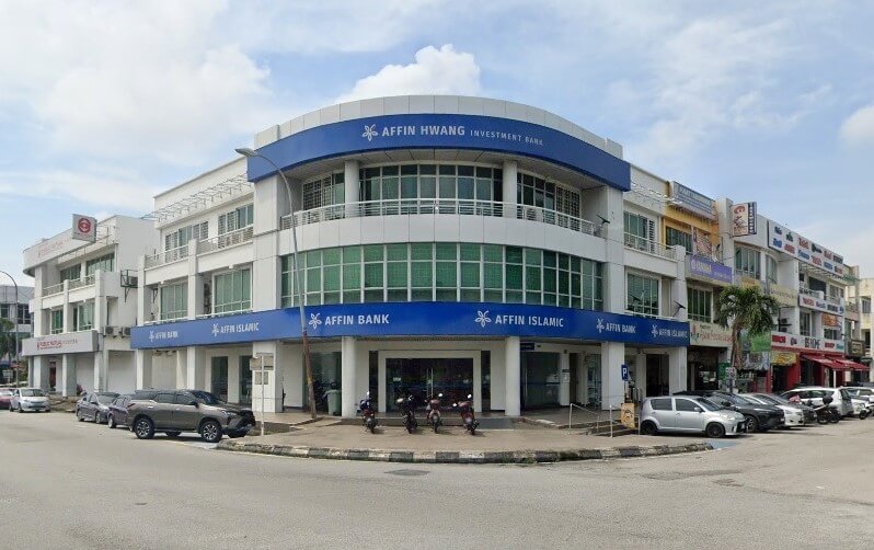 Sudut bangunan komersil bertingkat berwarna putih yang menempatkan Affin Bank, Affin Islamic dan Affin Hwang Investment Bank kelihatan, memaparkan papan tanda berwarna biru yang menarik yang melilit muka bangunan bulat dengan kenderaan diletakkan di hadapan