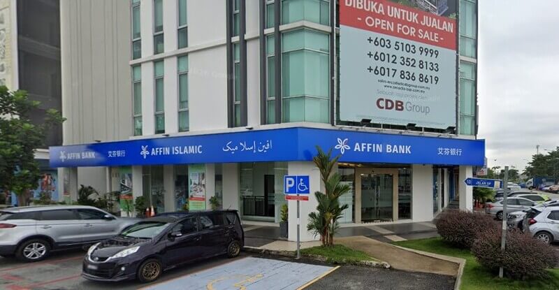 Pandangan luar cawangan Affin Bank Bandar Saujana Putra dan Affin Islamic bertingkat di sudut bangunan komersial dengan beberapa buah kereta diletakkan di hadapannya.