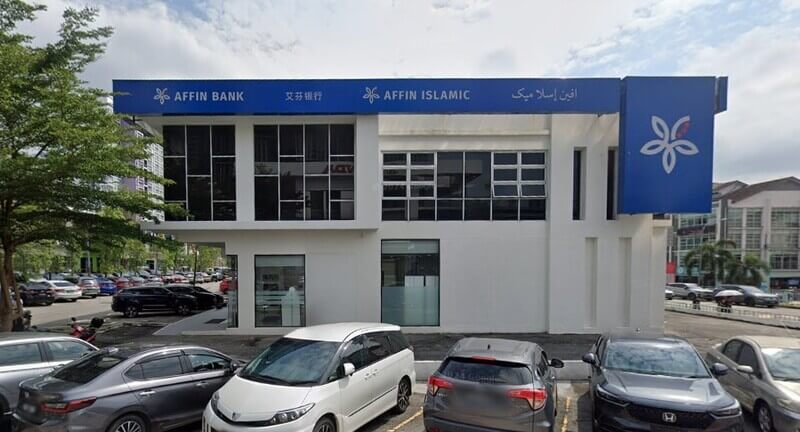 Pandangan hadapan bangunan cawangan AFFIN Bank Taman Equine dan AFFIN Islamic dua tingkat dengan papan tanda biru serta kawasan tempat letak kereta di hadapannya