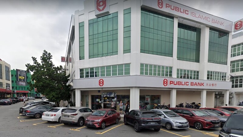 Pandangan luar bangunan cawangan Public Bank Bandar Puteri Puchong dan Public Islamic Bank berbilang tingkat dengan kenderaan diletakkan di hadapannya.
