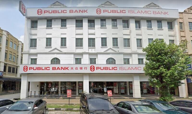 Pandangan hadapan bangunan cawangan Public Bank Kota Kemuning dan Public Islamic Bank empat tingkat berwarna putih dengan beberapa buah kereta diletakkan di tempat letak kereta di hadapan premis.