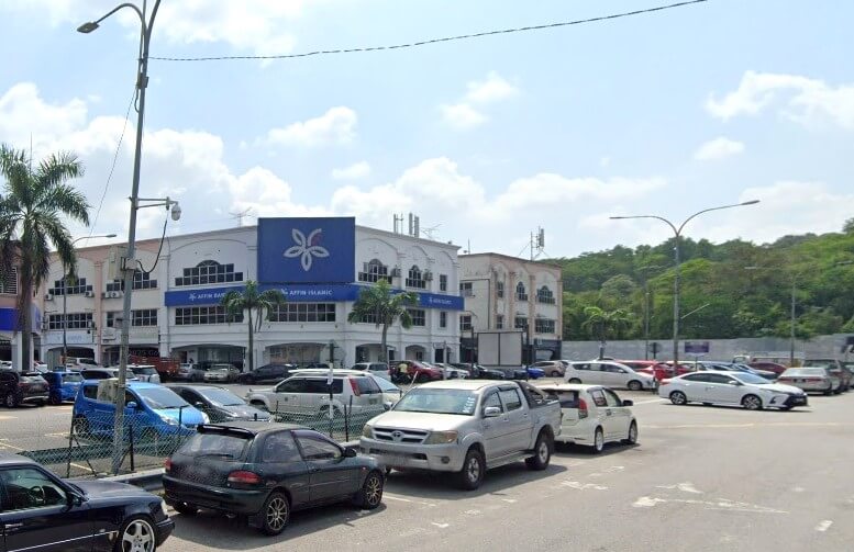 Bahagian luar bangunan Affin Bank dan Affin Islamic berwarna putih dengan logo biru besar, terletak di belakang kawasan parkir yang sibuk dengan kereta