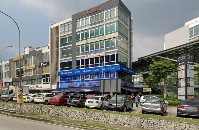 Bangunan komersial bertingkat pada waktu siang dengan cawangan Affin Bank dan Affin Islamic di tingkat bawah, dan restoran Alif Bistro di bawah papan tanda bank, dengan kereta diletakkan di hadapan
