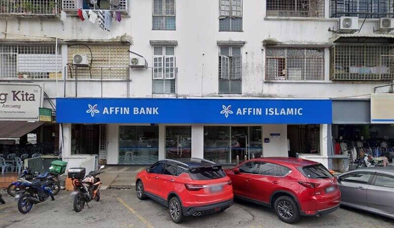 Pandangan hadapan cawangan AFFIN Bank dan AFFIN ISLAMIC di tingkat bawah sebuah bangunan kedai, dengan dua buah kereta merah diletakkan di hadapannya.