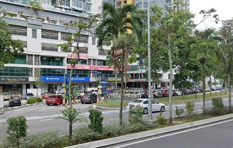 Pemandangan jalanan deretan rumah kedai komersil moden, menampilkan cawangan Affin Bank dan perniagaan lain seperti Dr. Nazelia Clinic, dengan papan tanda "Vista Alam" boleh dilihat dalam median berlandskap. Kereta diletakkan di hadapan dan di jalan