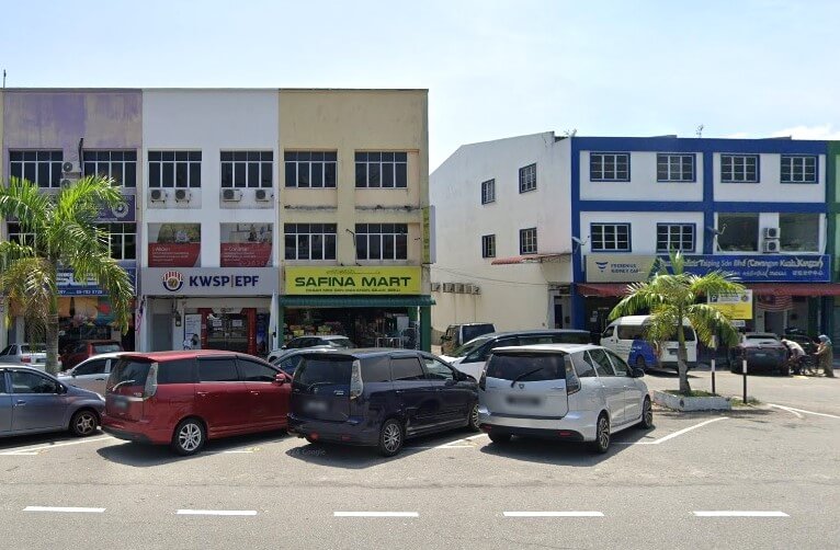 Pemandangan jalan deretan kedai di Kuala Kangsar, dengan pejabat KWSP/EPF (Employees Provident Fund) kelihatan di tingkat bawah bangunan di sebelah kiri, bersebelahan dengan kedai bernama "Safina Mart". Beberapa buah kereta parkir di hadapan