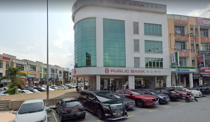 Bangunan cawangan Public Bank Bandar Mahkota Cheras di kawasan rumah kedai dengan parkir kereta di bahagian hadapan.