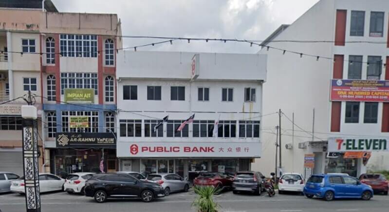 Pemandangan cawangan Public Bank di Kuala Dungun tiga tingkat di kawasan rumah kedai dengan papan tanda bertulis "PUBLIC BANK" dan tulisan Cina