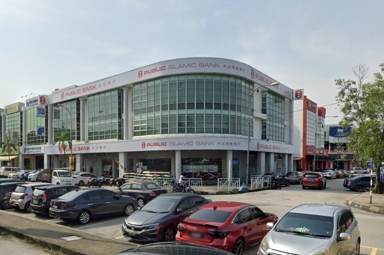 Pemandangan luar bangunan moden cawangan Public Bank dan Public Islamic Bank bertingkat di Bandar Bukit Tinggi, menampilkan fasad kaca melengkung di tingkat atas dan papan tanda merah di seluruh bangunan putih