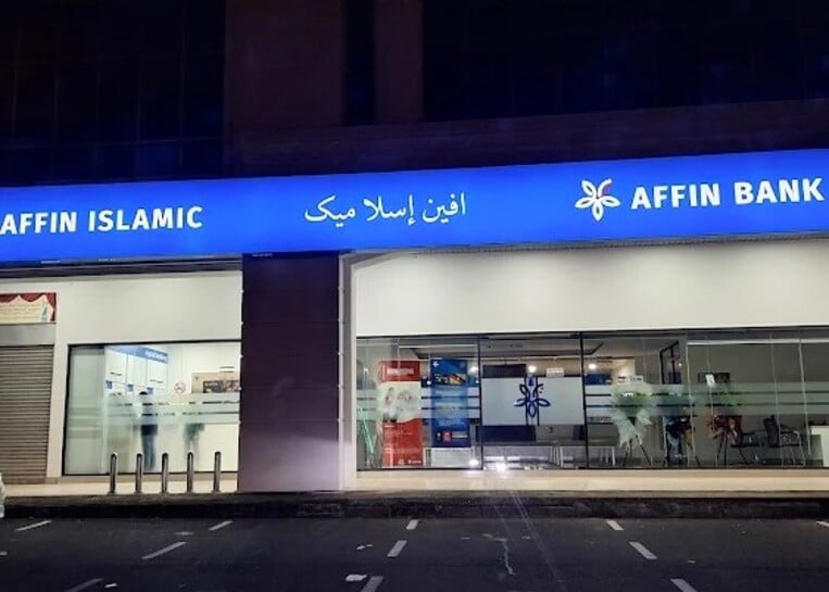 Pemandangan malam bahagian luar bangunan AFFIN BANK/AFFIN ISLAMIC, menunjukkan papan tanda biru panjang bercahaya dengan logo dan nama bank dalam bahasa Inggeris dan Arab/Jawi
