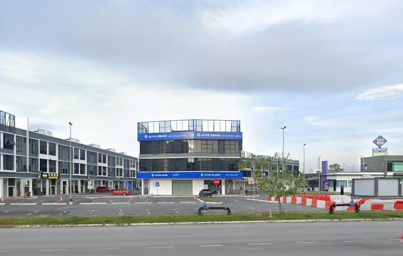 Bangunan biru dan putih tiga tingkat menempatkan cawangan AFFIN Hwang Investment Bank dan AFFIN ISLAMIC Bank, dikelilingi oleh tempat letak kereta kosong yang besar dan bangunan komersial moden di latar belakang