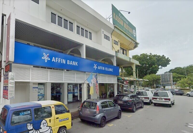 Pandangan luar premis cawangan Affin Bank Bayan Baru dan Affin Islamic di bangunan rumah kedai bersama deretan kenderaan yang diletakkan di bahagian hadapan.