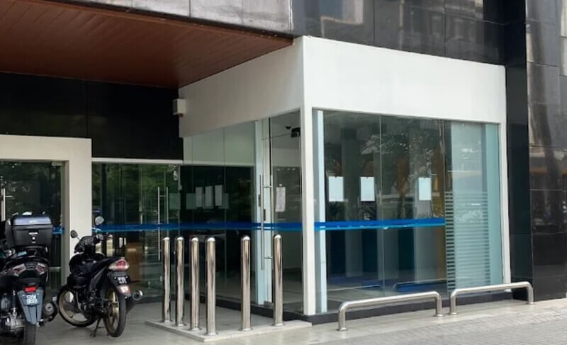 Pandangan hadapan pintu masuk cawangan AFFIN Bank di Chulan Tower dengan cermin kaca dan motosikal di hadapannya