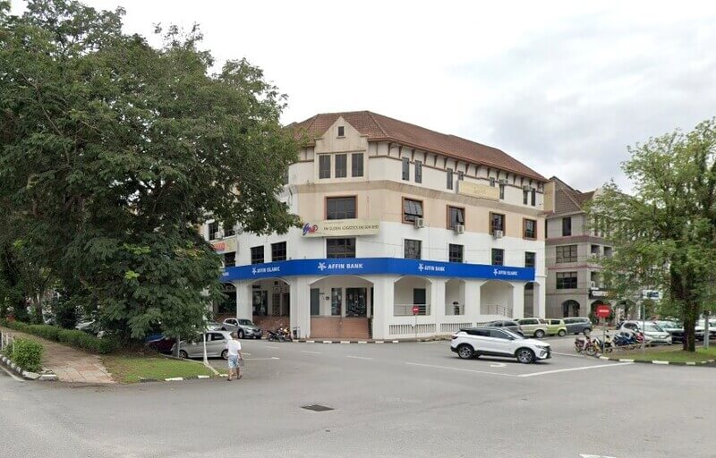 Sebuah bangunan sudut empat tingkat di Ipoh menampilkan cawangan Affin Bank dan Affin Islamic di tingkat bawah, dengan batu krim dan kuning air, bumbung berjubin coklat, dan kereta diletakkan di hadapan