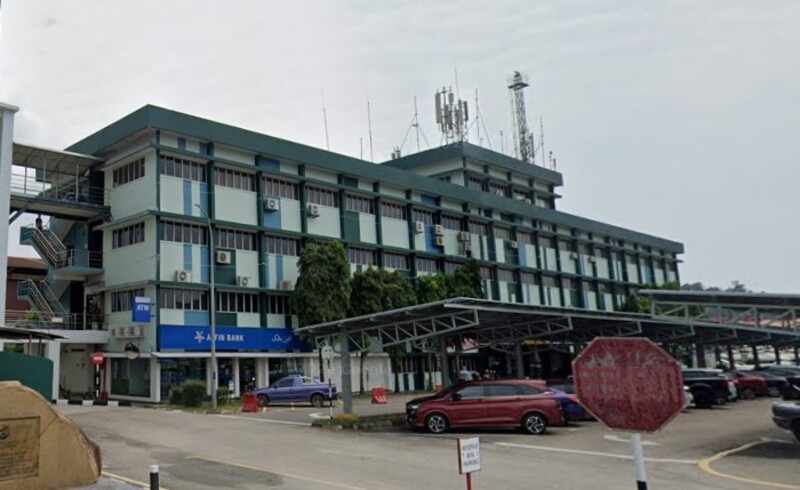 Pandangan luaran bangunan komersial beberapa tingkat dengan papan tanda Affin Bank di Kemaman Supply Base berawarna biru di tingkat bawah dan kawasan tempat letak kereta di bahagian hadapan