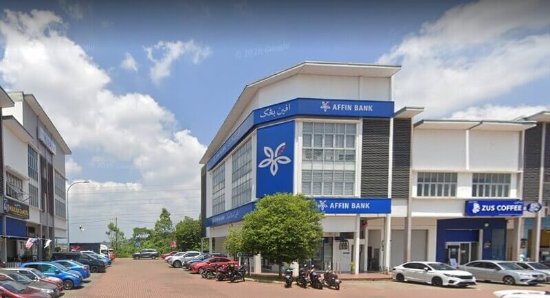 Pemandangan luar bangunan kedai dua tingkat yang menempatkan cawangan AFFIN Bank Kota SAS dengan papan tanda biru dan logo bunga ikonik, bersebelahan dengan premis ZUS Coffee di Kota SAS, Kuantan.