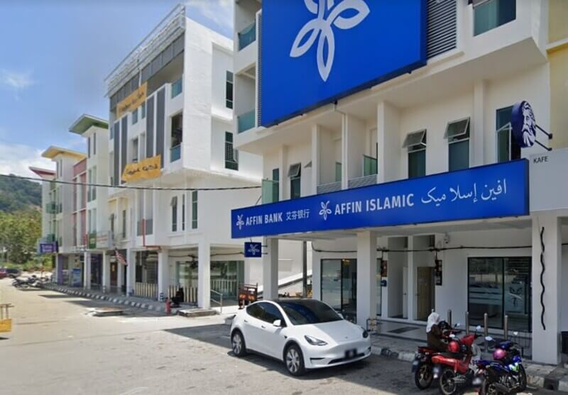 Bangunan cawangan Affin Bank Lumut dan Affin Islamic berprestij dengan papan tanda biru, tempat letak kereta, dan kereta elektrik putih di hadapannya