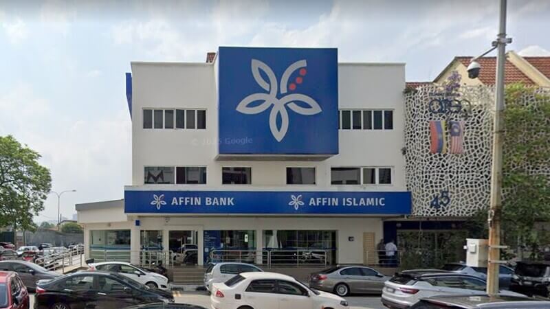 Pemandangan hadapan bangunan cawangan Affin Bank Taman Tun Dr. Ismail dan Affin Islamic bertingkat di kawasan perbandaran dengan kereta diletakkan di bahagian hadapan