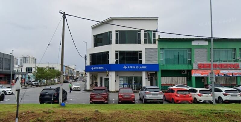 Bangunan luaran AFFIN Bank Bandar Meru Raya tiga tingkat di lot tepi dengan papan tanda biru dan tempat letak kereta di hadapan.