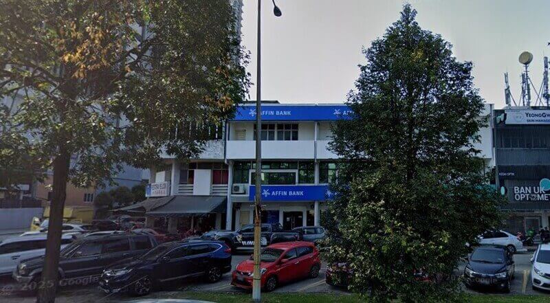 Pemandangan luar cawangan kedai dua tingkat AFFIN Bank di Seri Petaling dengan papan tanda biru dan kawasan tempat letak kereta di hadapan.