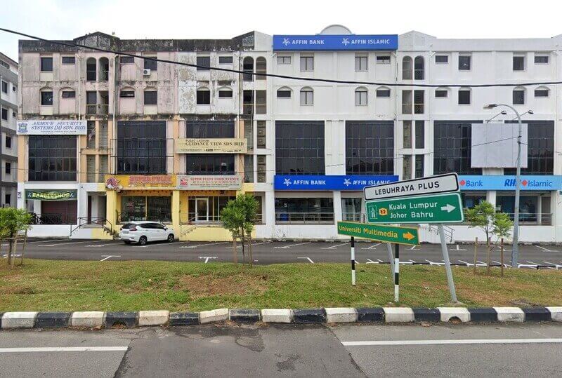 Pandangan luar Affin Bank dan cawangan Affin Islamic di Bukit Baru, terletak dalam deretan bangunan komersial dengan papan tanda jalan untuk lebuh raya PLUS dan Universiti Multimedia di latar depan