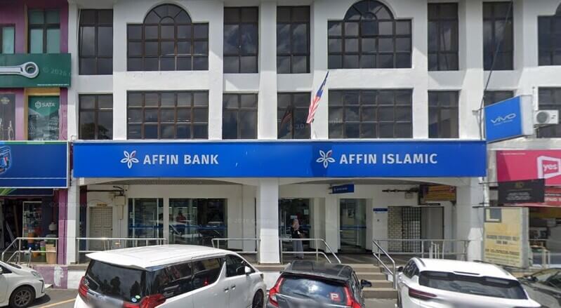 Pemandangan luar cawangan Affin Bank Nilai dan Affin Islamic pada bangunan rumah kedai tiga tingkat, dengan beberapa buah kereta diletakkan di bahagian hadapan.